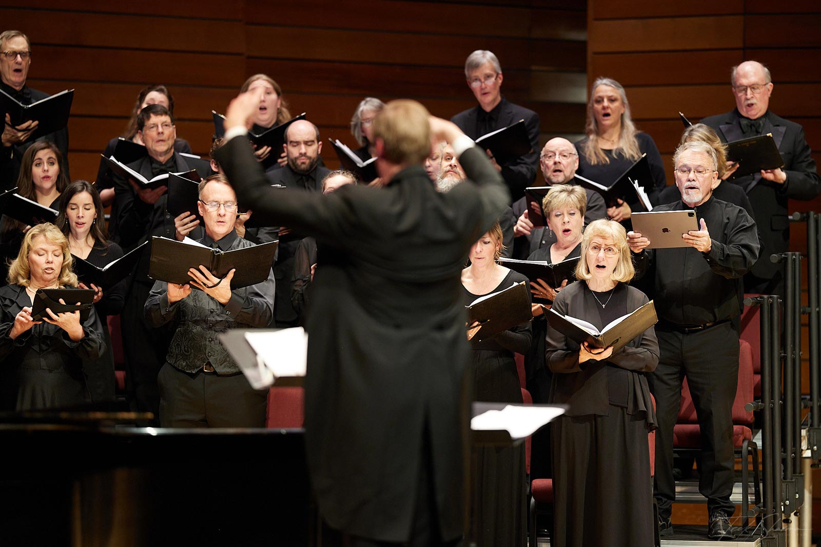 Dr. Paul French directing Southern Oregon Repertory Singers performing on stage at SOU music hall in Ashland, Oregon